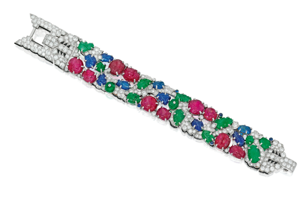 A rare and beautiful Cartier Tutti Frutti bracelet; Art Deco era, circa 1930. Diamonds with carved rubies, emeralds, and sapphires. Flat lay.
